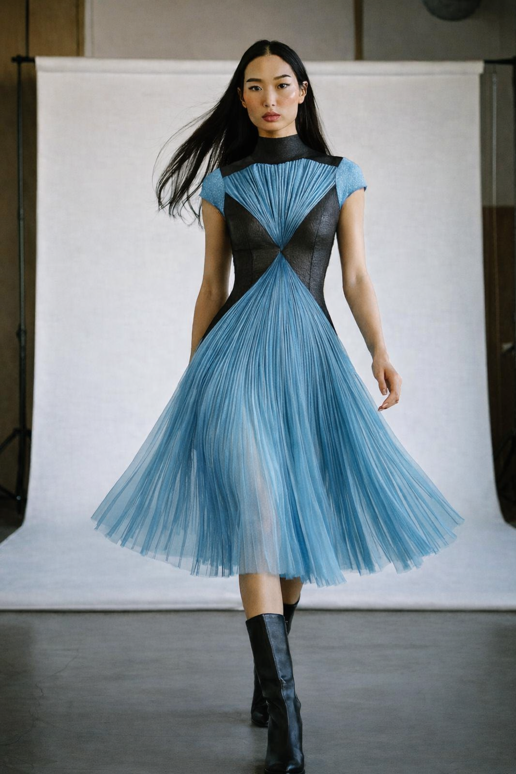 Model in an unusual turquoise tulle dress short sleeves full skirt  knee length  black V shape bodice highlights the waist